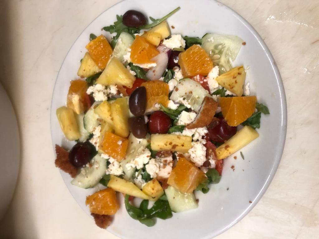 Mediterranean Arugula Fruit Salad · Arugula,Pineapple, Cucumber,Red Onion, grape tomatoes, feta cheese and grapes tossed in olive oil and lemon juice