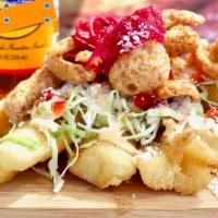 Yuca Sancochada con Chicharron · Yucca root fried with special seasoning topped with fried pork pieces, pickled cabbage, and ...