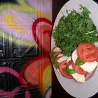 Caprese Salad · Fresh mozzarella, tomatoes and basil on arugula.