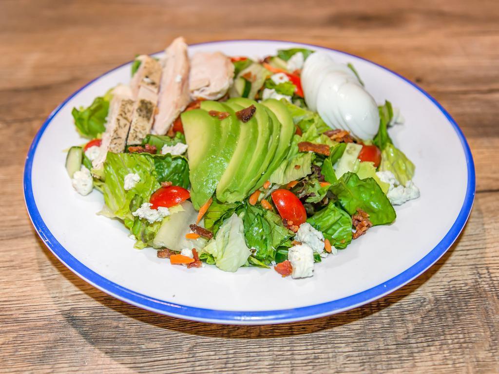 Empire Cobb Salad · A staggering feat of salad perfection. This empire is built with grilled chicken, crispy bacon, tomato, sliced egg, diced cucumber, crumbled blue cheese and avocado on a bed of fresh greens.