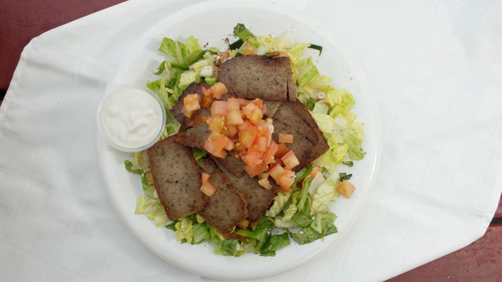 Lamb & Beef GYRO over Salad · Seasoned grilled Lamp and Beef served over Mixture of chopped  lettuce, tomatoes, cucumbers mixed with our house Mediterranean dressing. Comes with Tahini Sauce on the side.