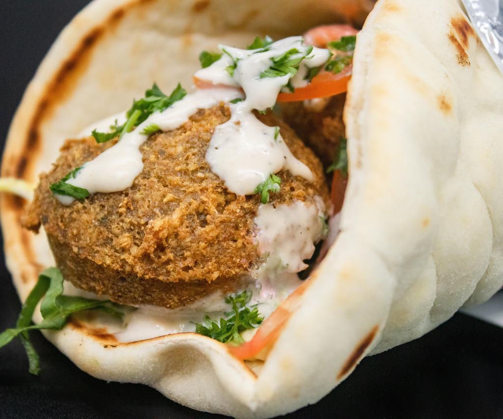 Falafel Sandwich · Delicious, golden falafel balls quickly deep fried. wrapped in a pita with hummus, tahini sauce, lettuce, and tomato.