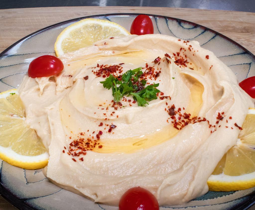 Hummus Plate served with warm pita · House made hummus with garlic, lemon juice  and tahini sauce. Served with pita bread.