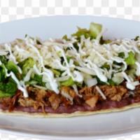 Huarache · Topped with Beans, meat of choice , lettuce, sour cream, white powder cheese.