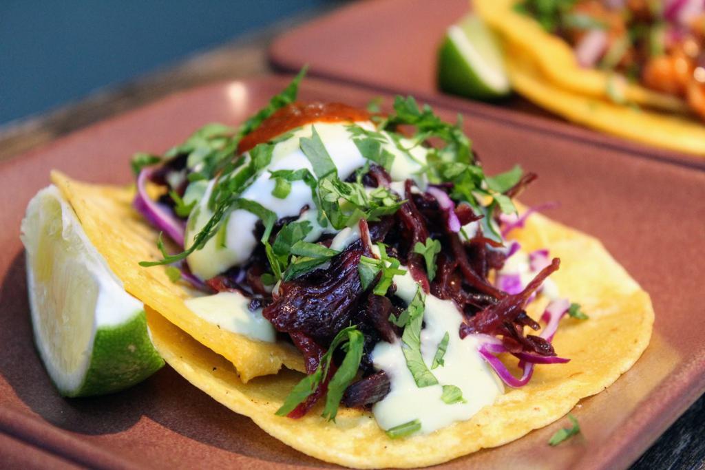 Hibiscus Flower Tacos · Award winning* Caramelized hibiscus flowers and onions, 
cabbage, avocado mousse, cilantro, crema, agave, salsa roja. Gluten free, soy free, and nut free. Contains 2 tacos.
*2017 LA's Best Vegan Taco - Judge's Choice