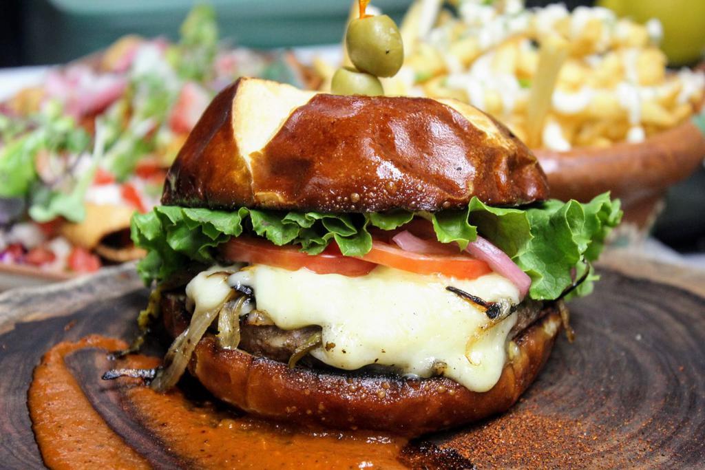 Om Burger · Seared impossible meat, roasted poblano pepper, charred onion, coconut cheese, green leaf, tomato, toreado aioli, pretzel bun. Nut-free. Add avocado for an additional charge.