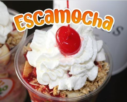 Escamocha · Pear, apple, banana, cantaloupe, granola, condensed milk, strawberry juice, and whipped cream in a cup.