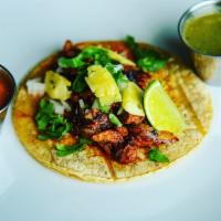 Taco al Pastor · Thin sliced pork marinated in guajillo sauce, onions, cilantro, lime, fresh pineapple.