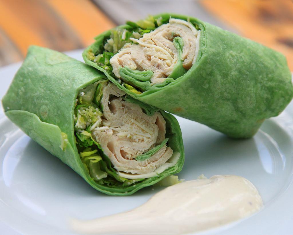 Chicken Caesar Wrap · Our spin on the classic chicken caesar wrap --- chicken, greens, and parmesan packed into a spinach wrap and air fried to perfection, served with caesar dressing on the side for your dipping pleasure. 
