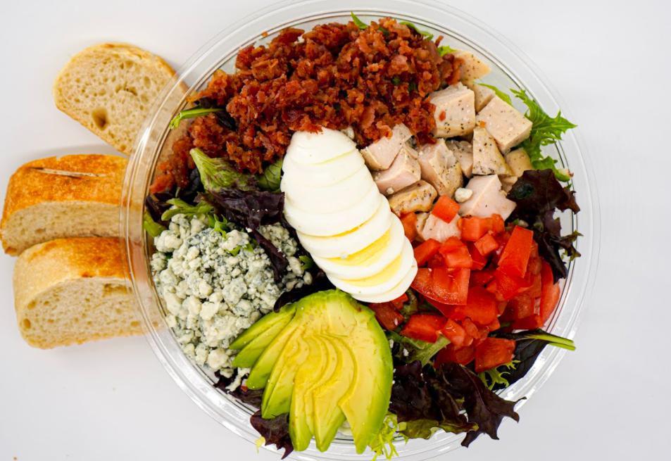 Cobb Salad · Chopped romaine and spring mix, cherry tomatoes, crisp bacon, sliced egg, avocado, grilled chicken, crumbled bleu cheese, and bleu cheese dressing on the side.