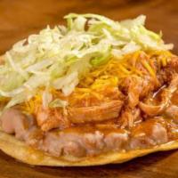 Chicken Tostada  · Refried beans, shredded chicken in red sauce, cheese, and lettuce.