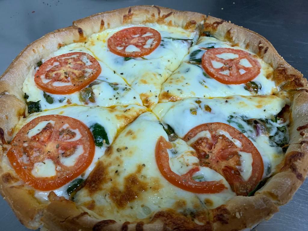 Deep Dish Tomato Pizza · A deep dish style of our thin stuffed with your favorite ingredients topped with mozzarella and slices of tomato.