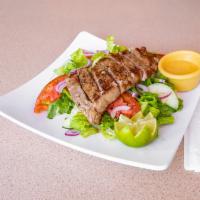 Steak con Camarones · New York steak with shrimp served with a side salad. Served with rice and black beans.