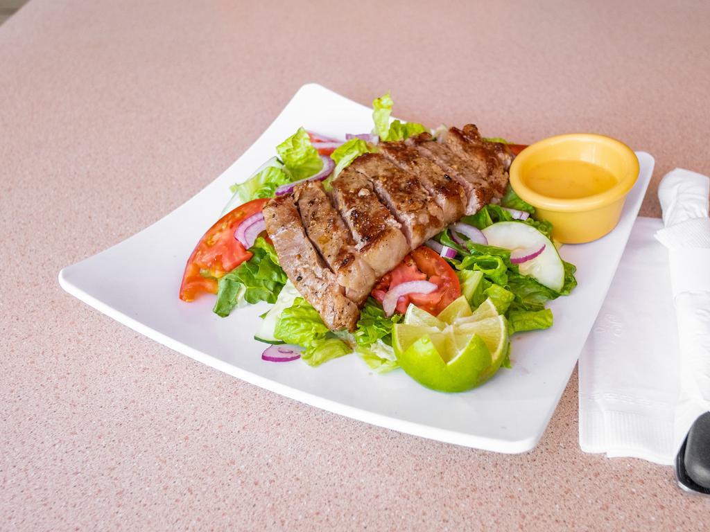 Steak con Camarones · New York steak with shrimp served with a side salad. Served with rice and black beans.