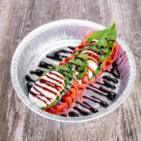 Caprese Salad · Slices of fresh mozzarella cheese and Roma tomatoes topped with fresh basil and balsamic dri...
