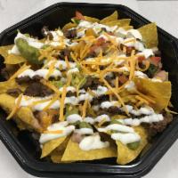 Carne Asada · Tortilla chips steak and topped with beans and melted cheese, guacamole sour cream and pico ...