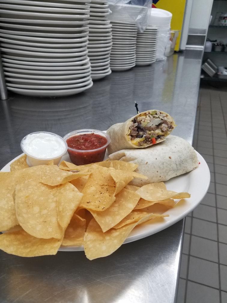 Steak Burrito · Juicy steak, rice blend, Cheddar Jack cheese, roasted corn, onions, black beans, poblano peppers, steak sauce, and wrapped in a flour tortilla, served with salsa, sour cream, and tortilla chips.