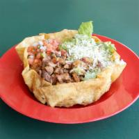 Crispy Taco Salad · Fresh romaine lettuce topped with black beans, shredded cheese, salsa fresca and guacamole s...