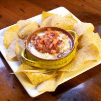 Chips and Bean Dip · Refried beans topped with cheese, tomato, onions and mild chunky salsa.