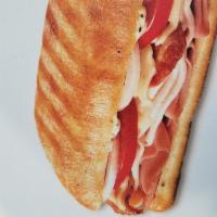 Ultimate Club Panini Sub · Slow-cured ham, oven-roasted turkey, crisp bacon, Swiss, tomatoes, and onion with peppercorn...