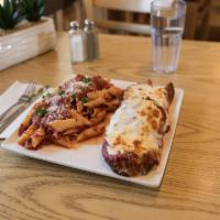 Chicken Parmigiana · Breast of chicken topped with marinara sauce and mozzarella, with side of pasta.