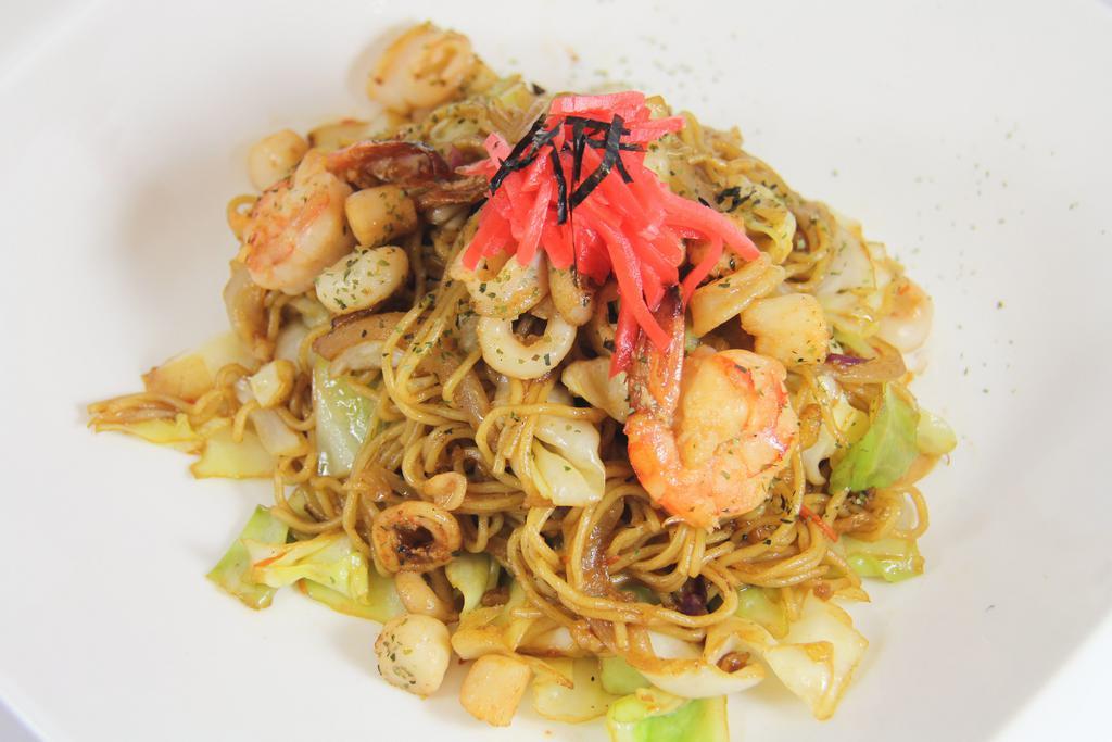 Seafood Yaki Soba · Stir-fried soba noodle with seafood (shrimp, calamari, and bay scallop) and vegetables (green cabbage, yellow onion, and carrot and red cabbage pieces) in yaki soba sauce topped with dry green seaweed and red ginger. Comes with a small portion of house salad.