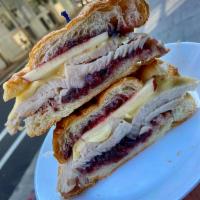 Turkey Brie Signature Sandwich · Oven-roasted turkey breast, melted brie cheese, cranberry relish on a warm croissant and ser...