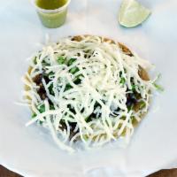 Steak Taco · Served with onions, cilantro, cheese on a corn tortilla and green salsa on the side.