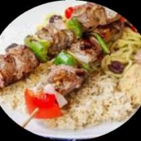 Pork Kebab With Rice and Greek Salad · Marinated pork on a skewer