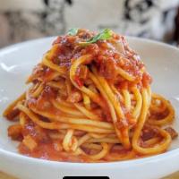 Spaghetti All' Amatriciana · 100% semolina pasta, all' Amatriciana spicy tomato, Guanciale pancetta, and basil.