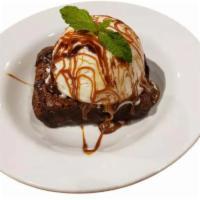 Chocolate Brownie Cake · Warm chocolate brownie cake with a scoop of vanilla ice cream topped with caramel fudge.
