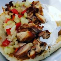 Chicken Shawarma · Grilled chicken breast cut into strips served on a pita roll with cucumber salad & tzatziki ...