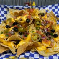 Nachos · House corn chips, nacho cheese, shredded cheese, pico, black olives, jalapenos and sour cream.