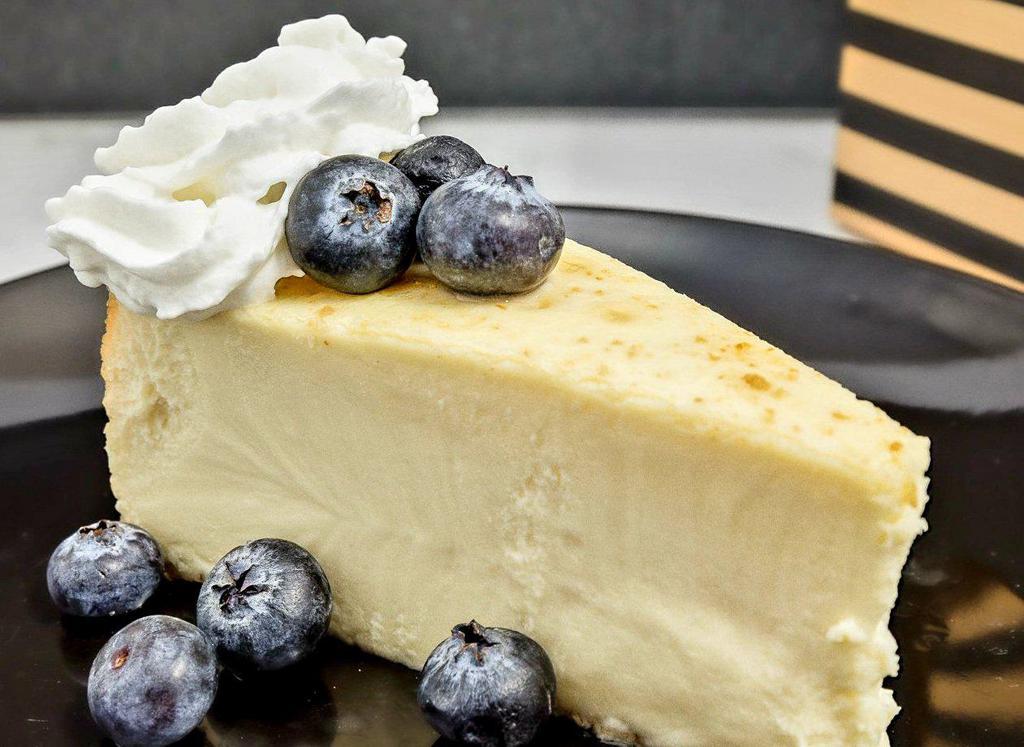 Plain New York Style Cheesecake · Sweet and creamy cheesecake, blueberries, whipped cream, graham cracker crust