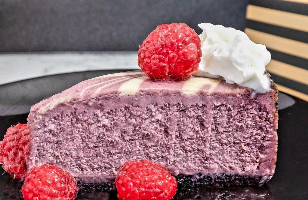 Raspberry Swirl Cheesecake · Sweet and creamy cheesecake, black raspberry puree, whipped cream, chocolate crumb crust