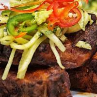 Costillas de Puerco with Yucca Fries · Pork ribs tossed in guava chipotle glaze & served with green papaya, jicama, and pepita slaw...