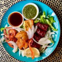 Assorted Tandoori Platter · Non-vegetarian. Combination of chicken tikka, seekh kebaab and tandoori prawns. Mint and tam...