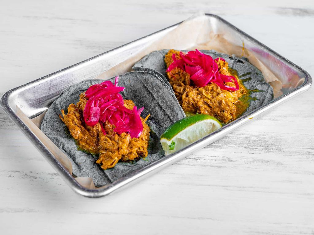 Cochinita Pibil Taco · 2 pieces. Pork shoulder marinated in achiote, pickled red onions, and habanero sauce.