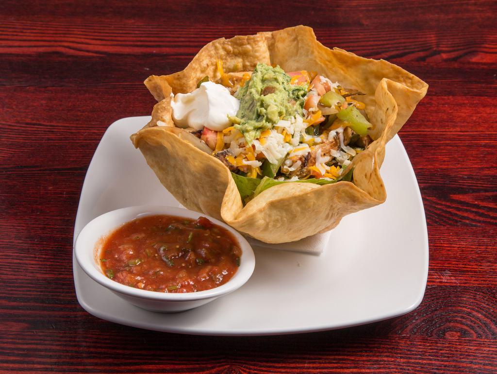 Fajita Salad · Marinated chicken or shrimp with sauteed onions and green peppers, tomatoes, chives, cheddar and Jack cheese. Served on fresh tossed garden greens in a crispy flour tortilla shell. Served with our house made salsa, sour cream and guacamole.