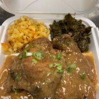 Smothered Chops · 2 pork chops smothered in our homemade onion gravy sauce served over bed of yellow rice incl...