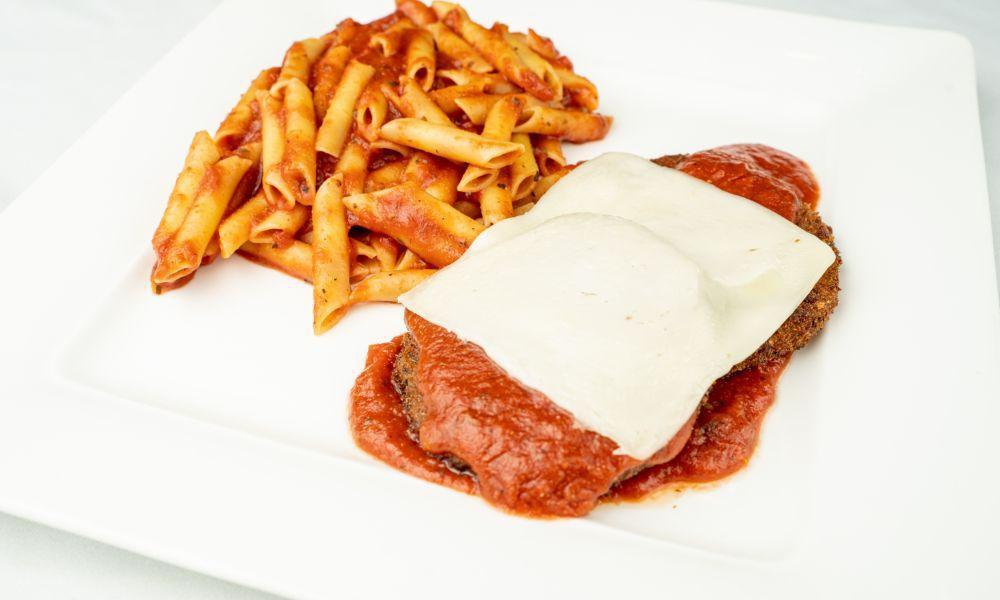 Eggplant Parmigiana · Fried eggplant with marinara sauce & baked in mozzarella cheese served with penne marinara