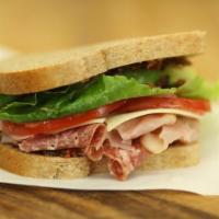 The Italian Sandwich · Ham, salami and provolone cheese topped with a roasted red pepper olive tapenade and drizzle...