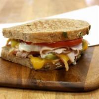 Turkey Chile Cheddar Melt Sandwich · Smoked turkey breast, sharp cheddar cheese, tomatoes, roasted green chilies and a house-made...