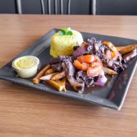 Lomo Saltado · Sauteed beef, red onions, tomato, french fries. Served over yellow rice.