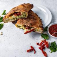 The Queen Calzone · Chicken, sundried tomato, basil pesto, feta, and mozzarella. Served with choice of dipping s...