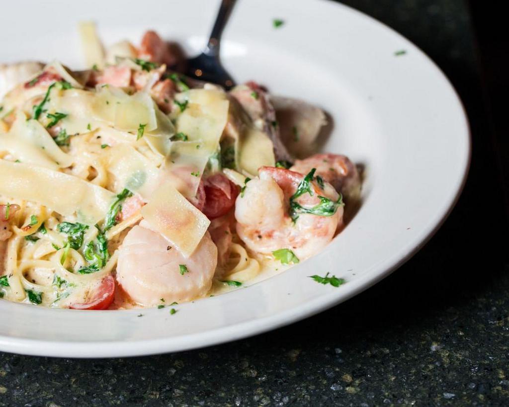 Seafood Linguine · Shrimp, scallops, salmon and tomatoes tossed in a garlic cream sauce.