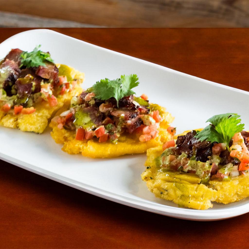 BBQ Tostones (Appetizer) · Three crispy tostones covered with Beef Brisket, Pulled Chicken or Chopped Pork topped with Pico de Gallo and Cilantro Aioli sauce.  