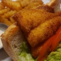 Cajun catfish sandwich  · A Fresh cut cajun catfish filet with lettuce and tomatoes on a French roll.  With tartar sau...