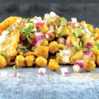 Samosa Chaat · Street Style. Stir-fried chickpeas, onions, tomatoes, and cilantro served atop a samosa cove...
