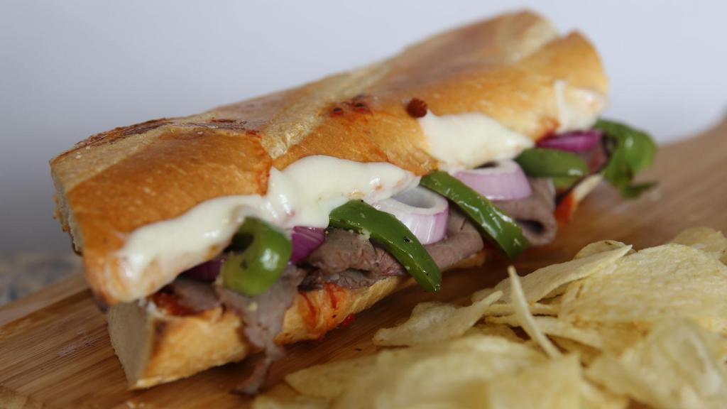 Roast Beef Hero · Roast beef, marinated bell peppers, onions, mozzarella, and marinara served HOT on a baguette.